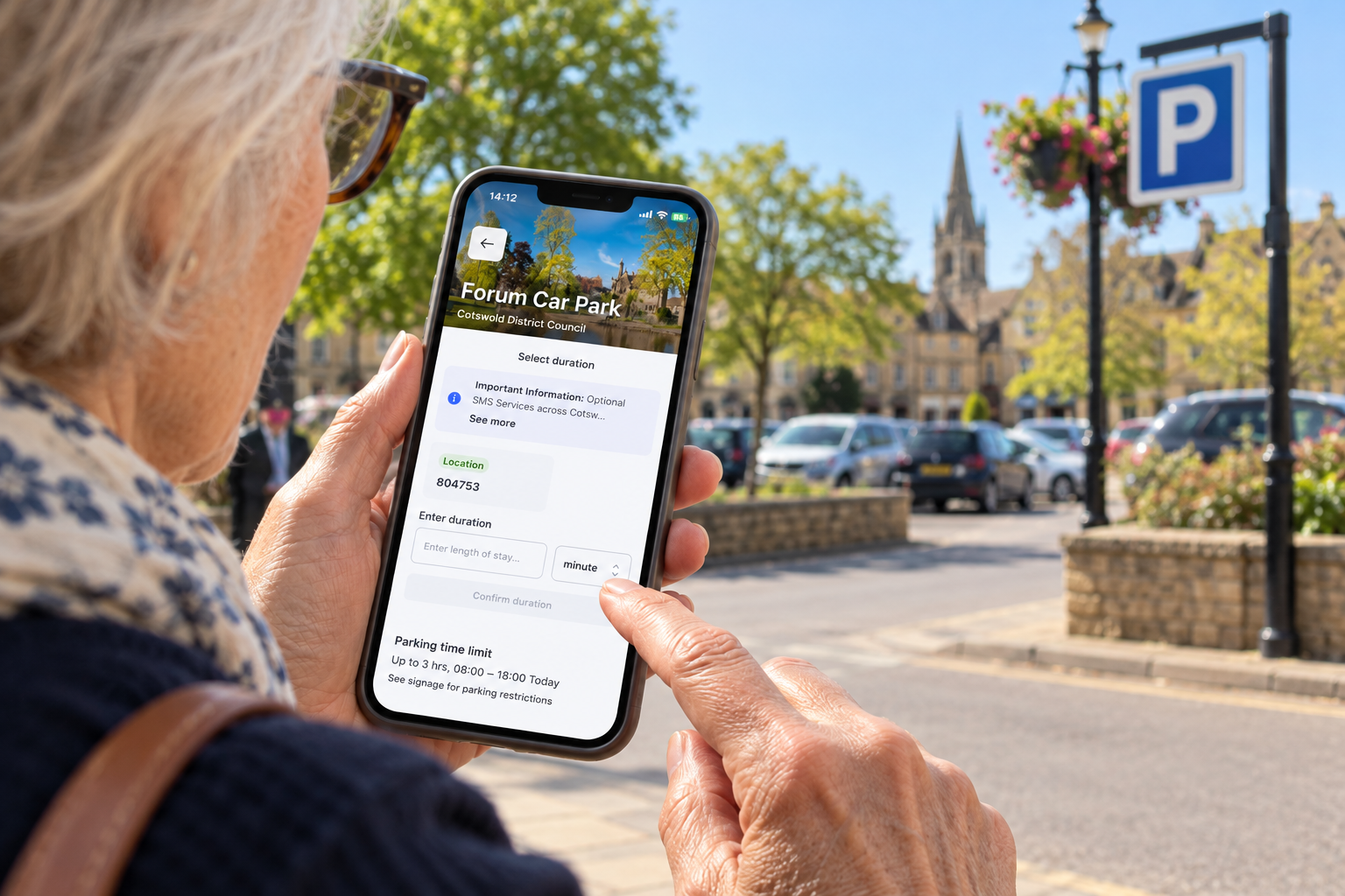 A person using a parking app on their phone in a Cotswold town
